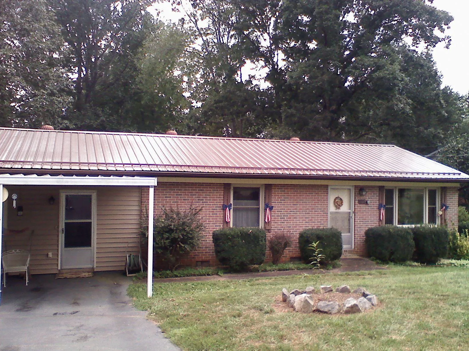 Bronze metal roof and carport on a brick ranch home — Roof Repair work by our crew in Kellogg